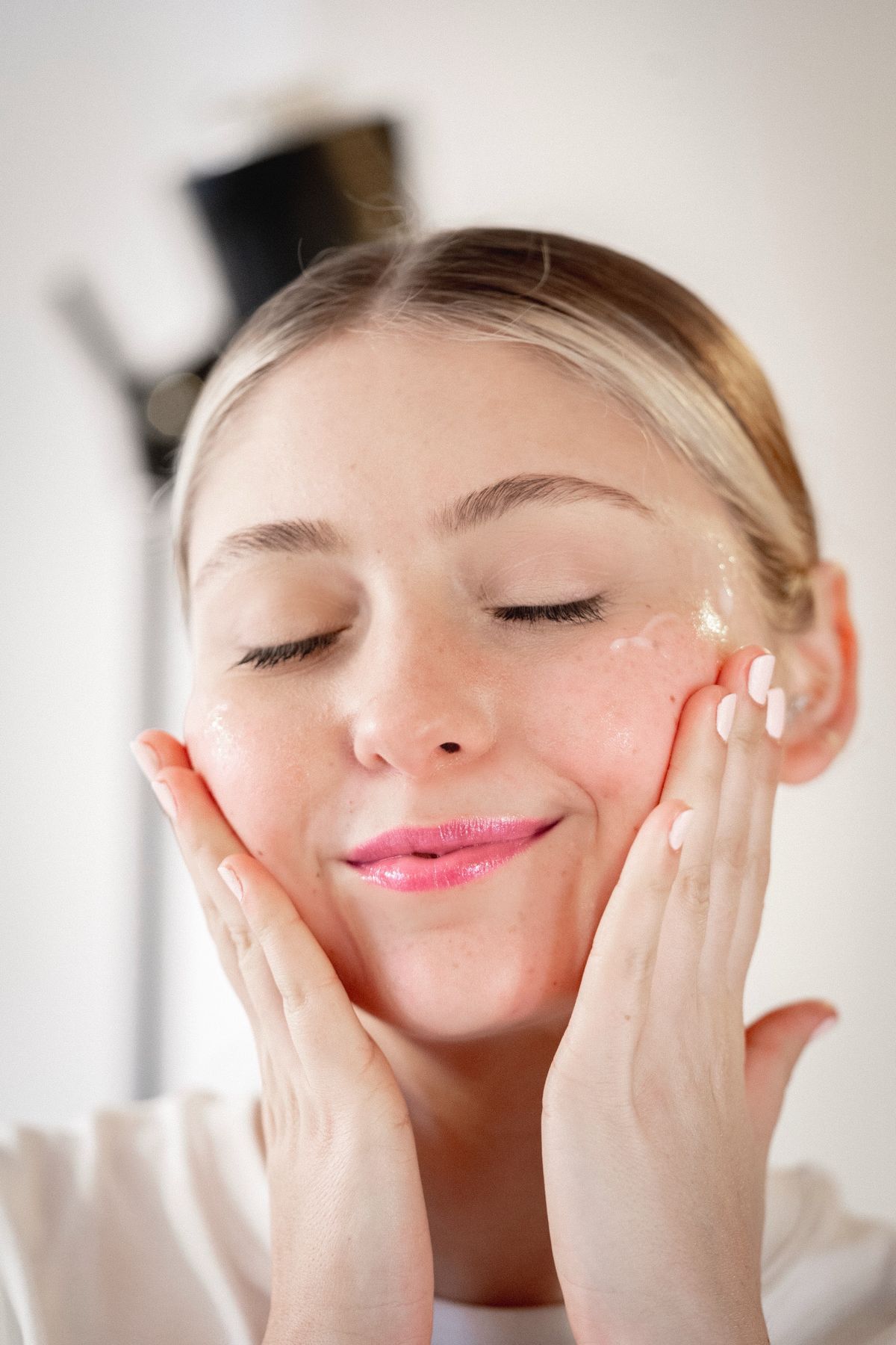 Rutina facial de noche: fotografía editorial de woman applying skincare cream in an evening routine
