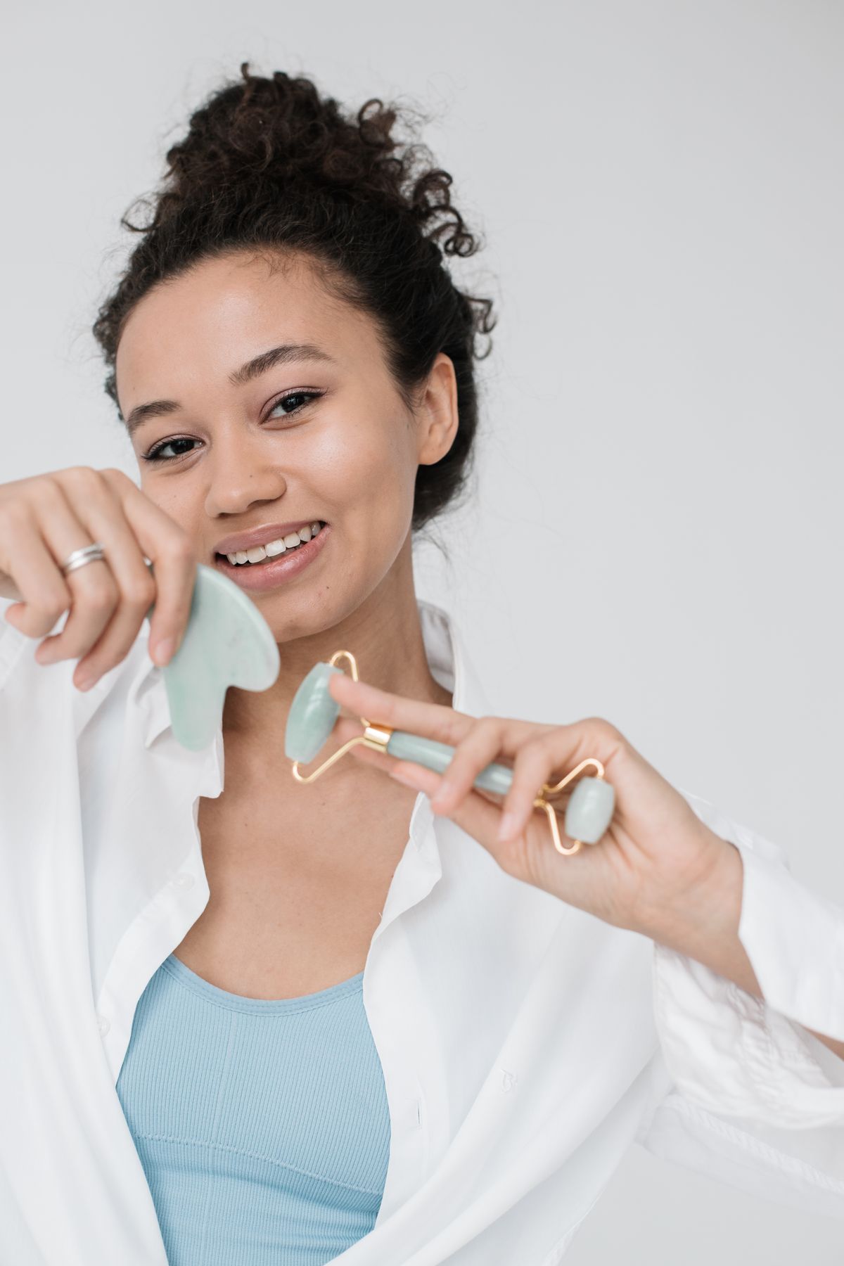 Gua sha vs rodillo facial: fotografía editorial de rostro usando rodillo y gua sha como herramientas