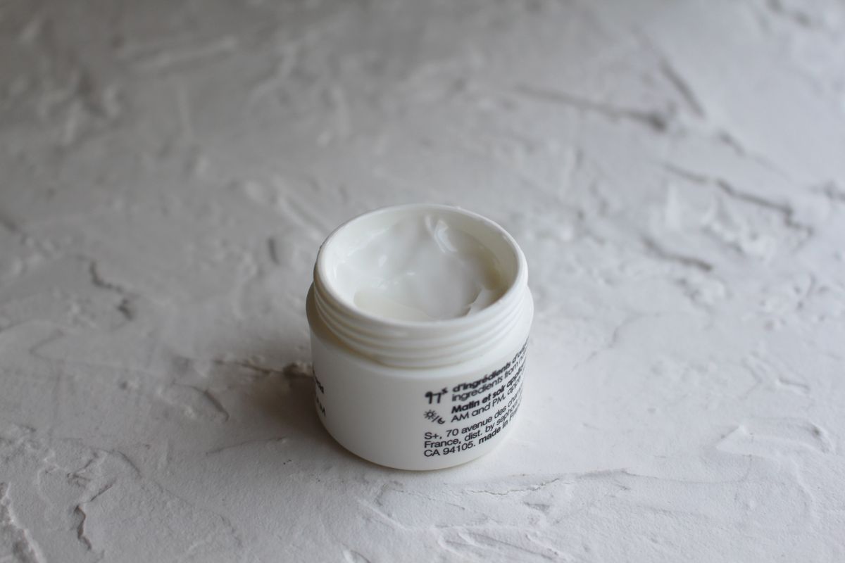 Los ingredientes con mejor evidencia para la flacidez facial: fotografía editorial de tarro de crema facial sobre una superficie texturizada