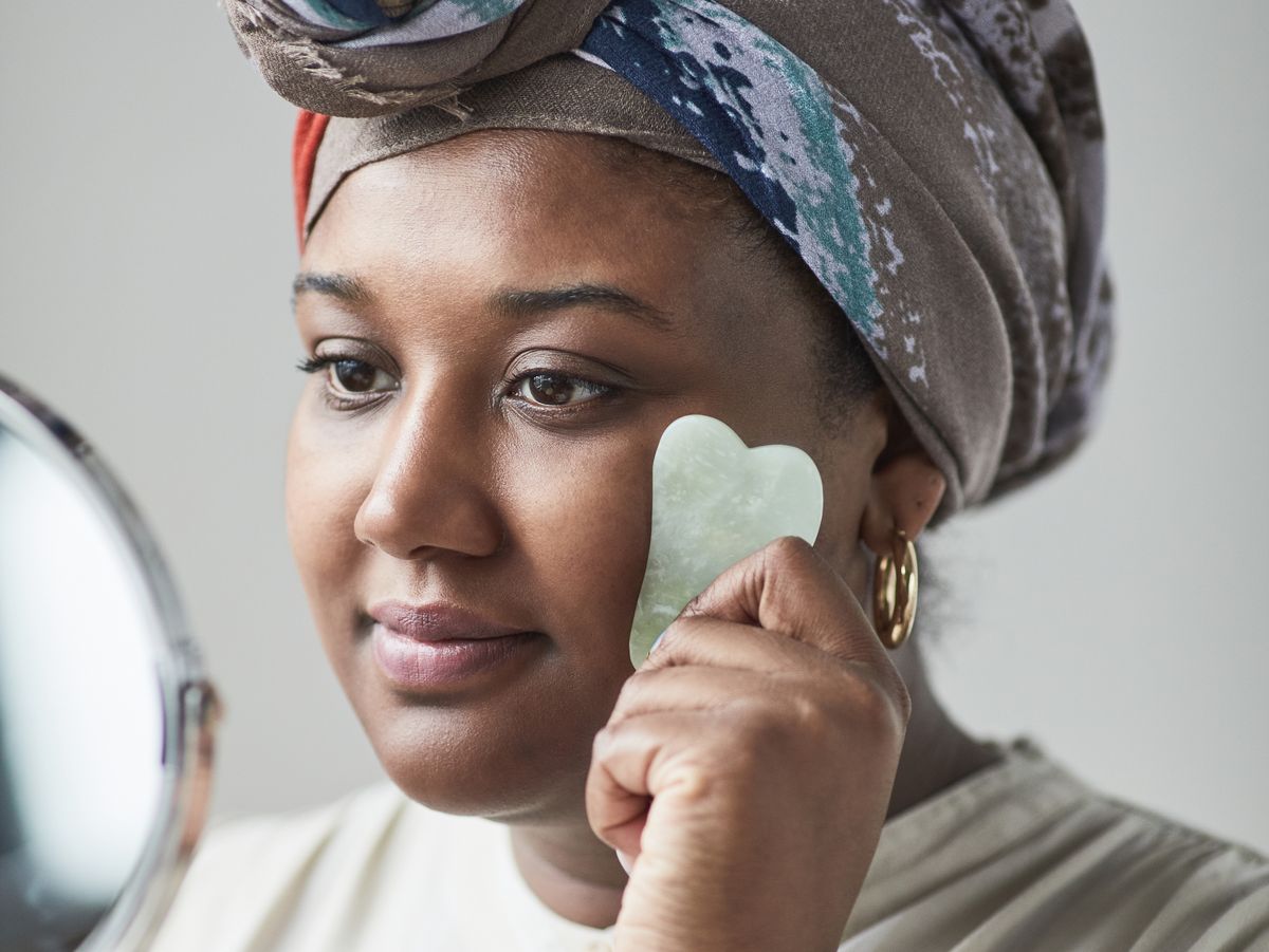 Masaje para la papada: fotografía editorial de mujer usando una herramienta de masaje facial sobre el rostro y la mandíbula