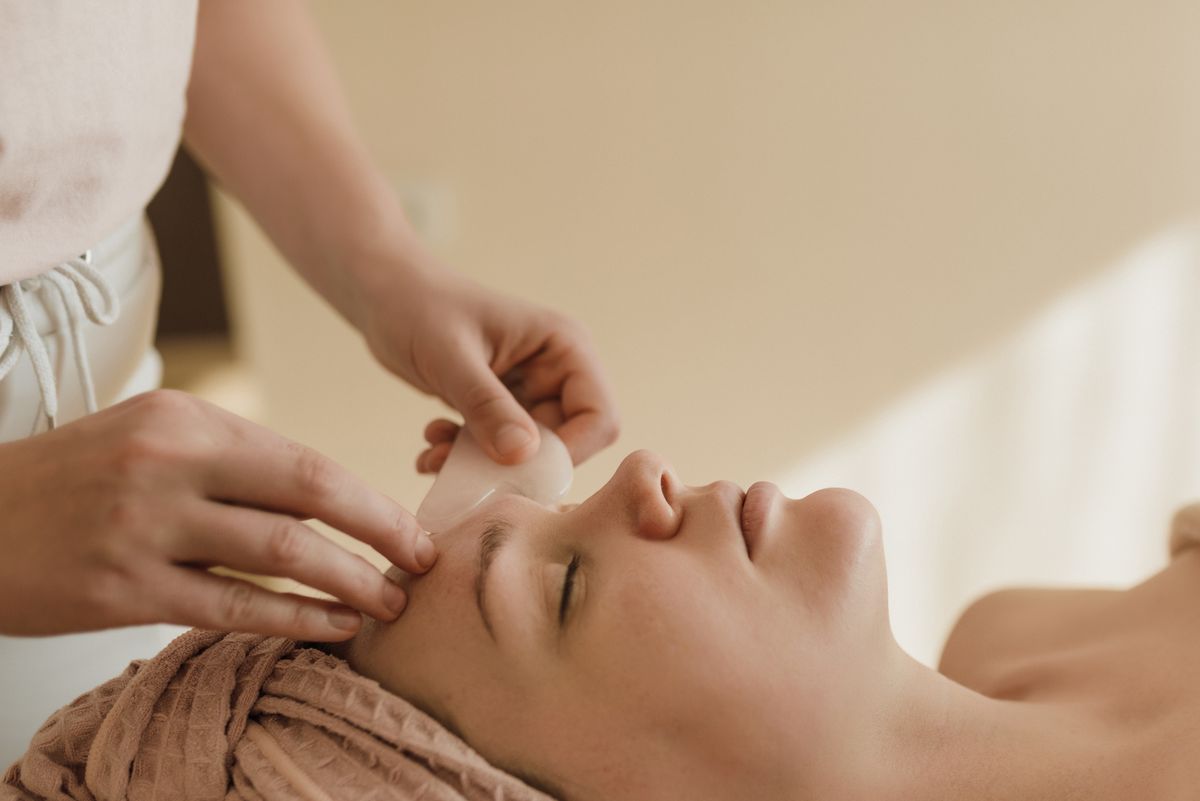 Rutina de skincare y yoga facial: fotografía editorial de masaje facial manual con herramienta